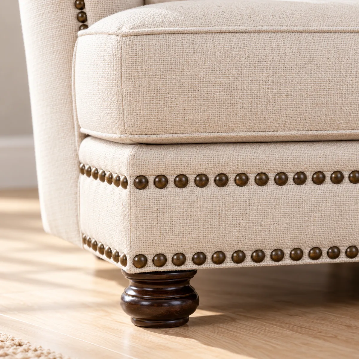 Clous et pied en bois foncé du fauteuil clouté