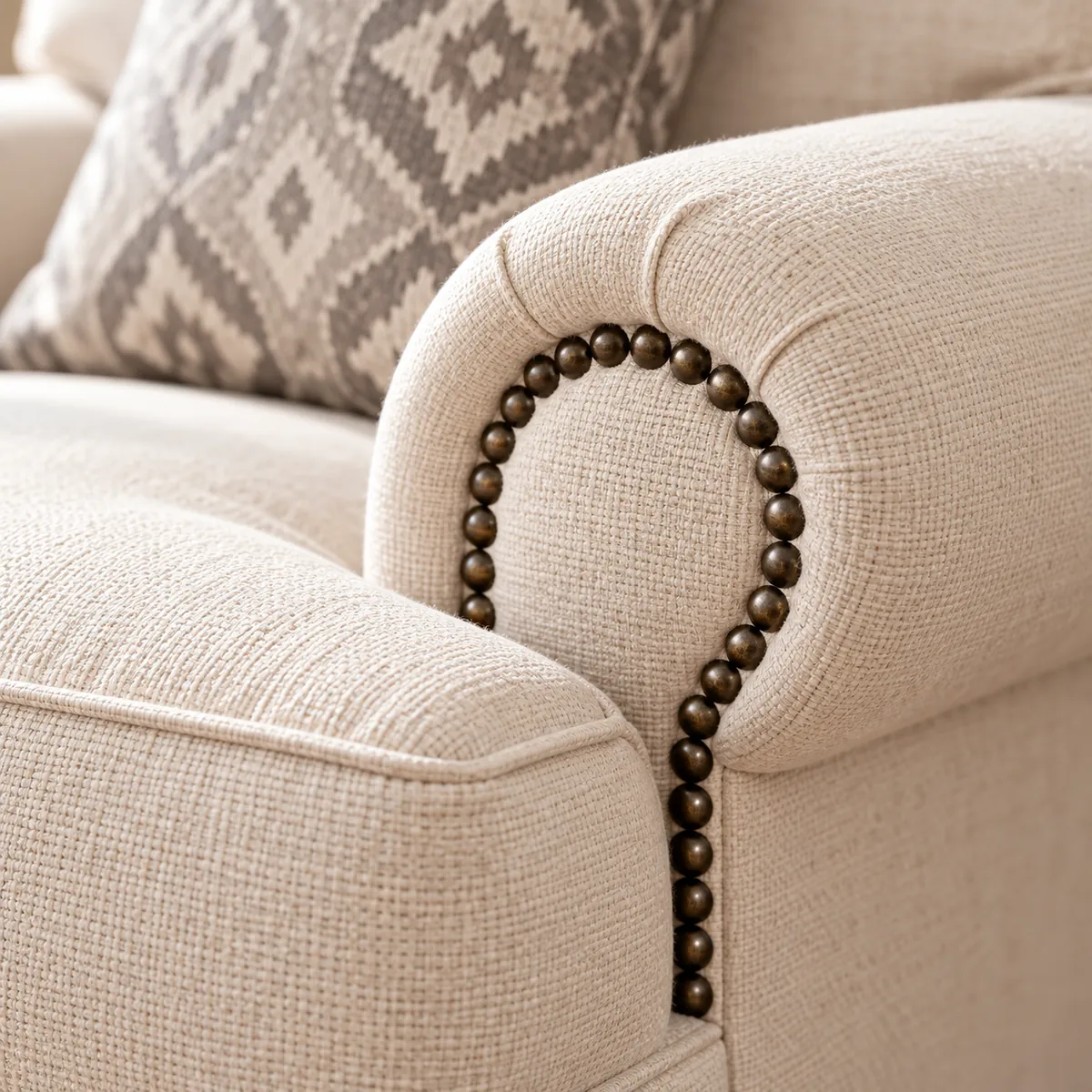 Tissu texturé et clous en laiton du fauteuil clouté