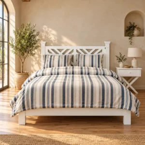 Lit Mirage en bois blanc et literie rayée dans une chambre beige