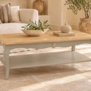 Table basse Louis XV patinée ivoire avec étagère dans un séjour beige
